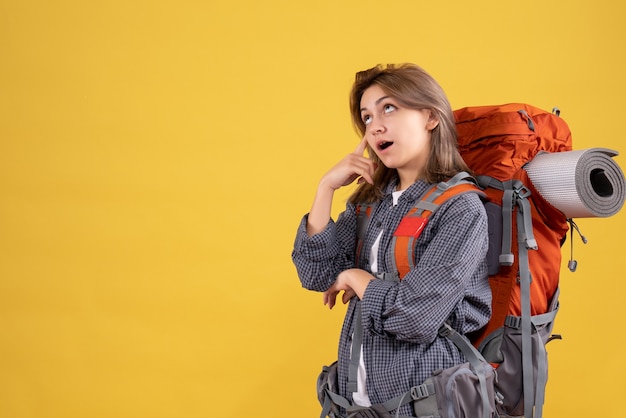 mulher viajante com mochila vermelha pensando em viagem