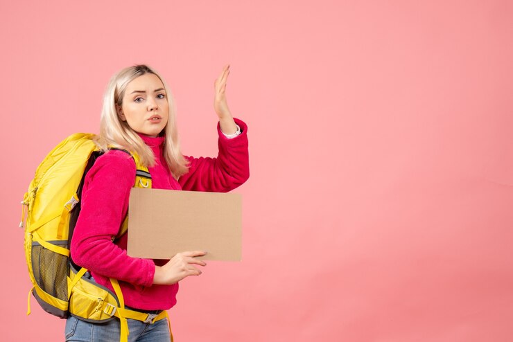 Foto grátis mulher viajante insatisfeita com mochila segurando papelão