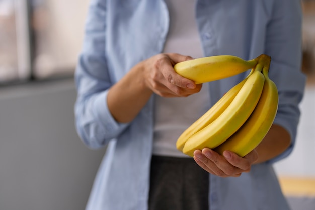 Mulher vista frontal, segurando bananas
