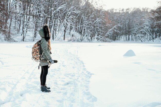 Mulher vista lateral com mochila no dia de inverno