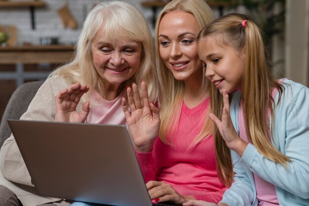 Mulheres acenando na frente de um laptop