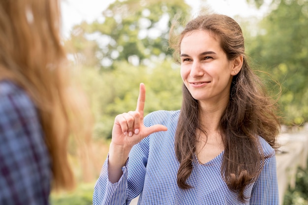 Mulheres adultas se comunicando através da linguagem gestual