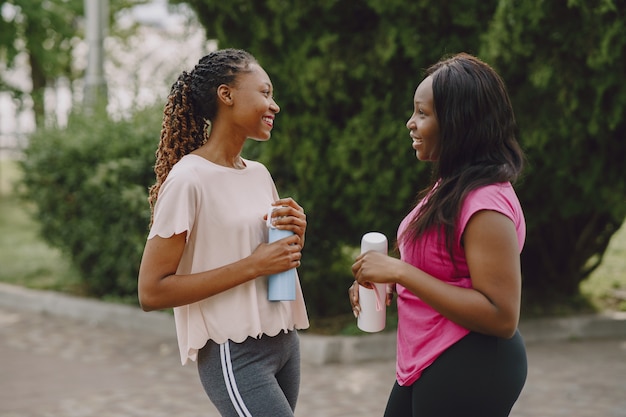 Mulheres africanas jovens saudáveis ao ar livre no parque de manhã. treinamento de amigos.