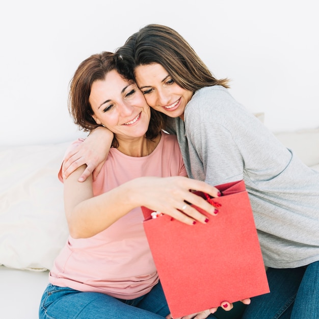 Mulheres alegres com saco de papel vermelho