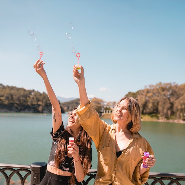 Mulheres alegres pegando bolhas