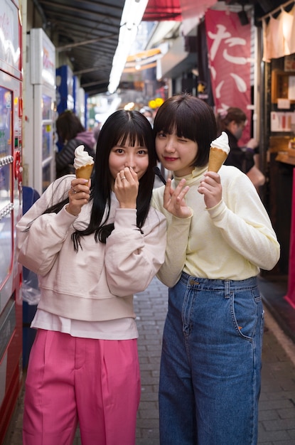Mulheres asiáticas de tiro médio com sorvete