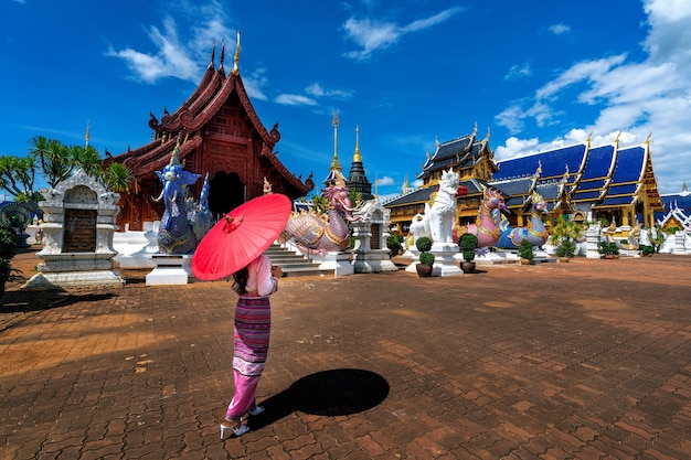 Mulheres asiáticas vestindo trajes tailandeses tradicionais de acordo com a cultura tailandesa no templo em chiang mai