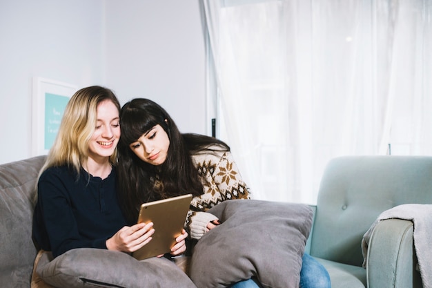 Foto grátis mulheres assistindo comprimido e relaxamento no sofá