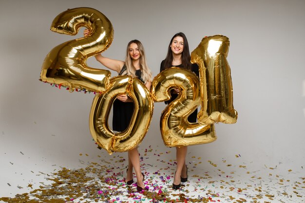 Mulheres bonitas com balões de ano novo 2021.