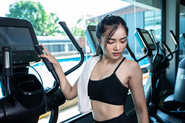 Mulheres bonitas fitness preparam-se para correr na esteira na academia.