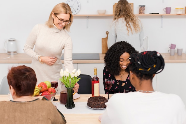 Mulheres bonitas que passam o tempo junto em uma cozinha