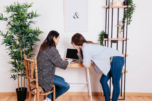 Mulheres bonitas que trabalham no laptop