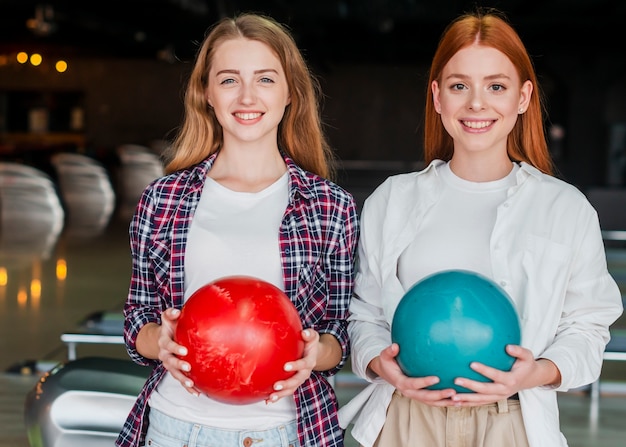 Foto grátis mulheres bonitas segurando bolas de boliche coloridas