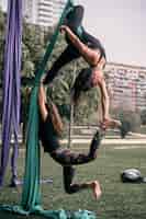 Foto grátis mulheres caucasianas praticando algumas posições difíceis de sedas aéreas juntas em um parque da cidade