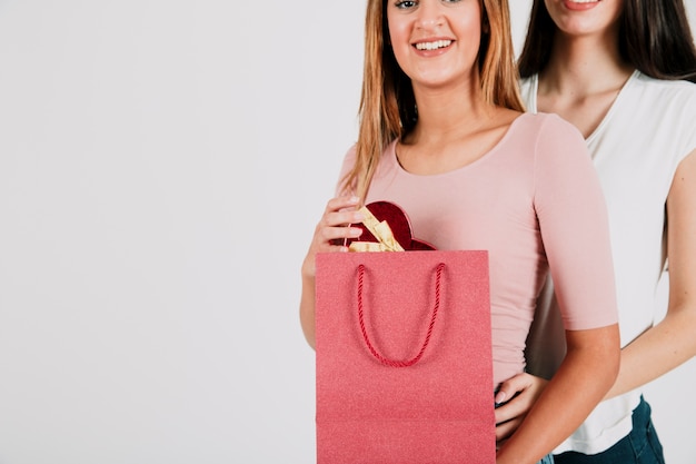 Mulheres com presente na bolsa de papel