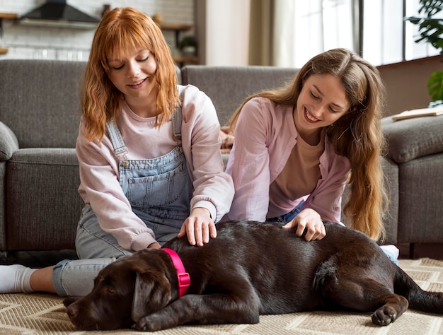 Mulheres com um tiro completo acariciando cachorro