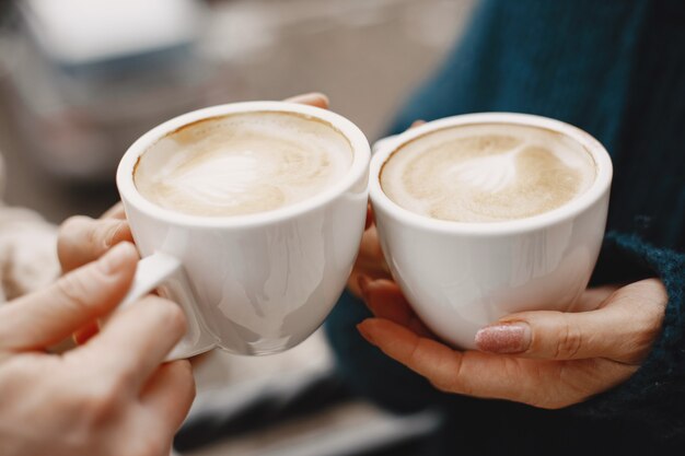 Mulheres com uma xícara de café. Férias maravilhosas nas montanhas. Tempo com neve.