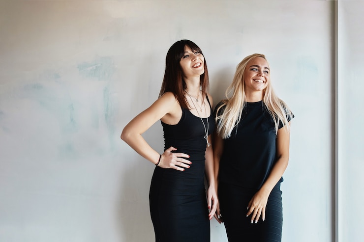 Foto grátis mulheres com vestido posando na parede