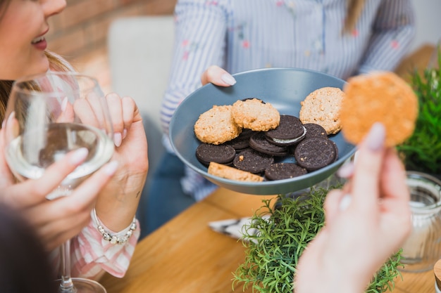 Foto grátis mulheres com vinho comendo biscoitos