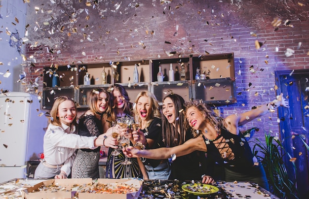 Mulheres comemorando com champanhe e confetes