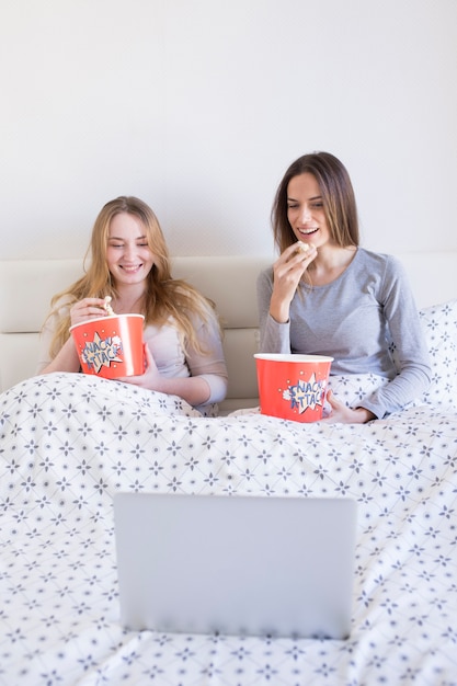 Mulheres comendo pipoca e assistindo filme