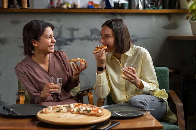 Foto grátis mulheres comendo pizza italiana tradicional juntos