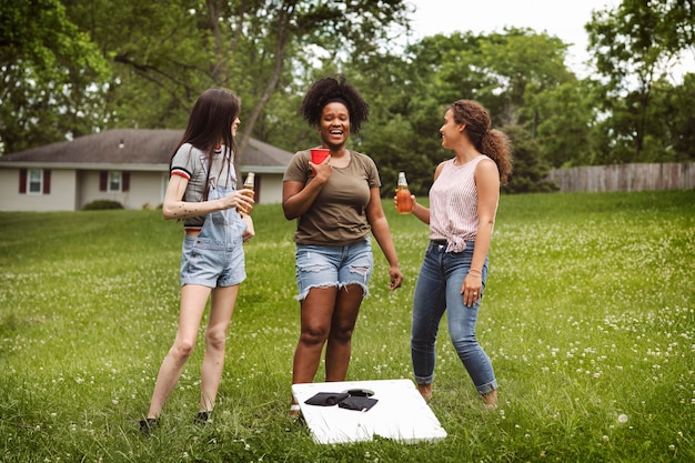 Mulheres conversando durante um jogo de cornhole no parque