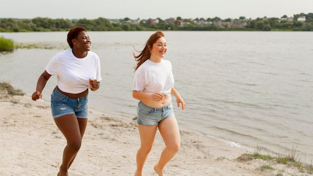 Mulheres correndo juntas na praia