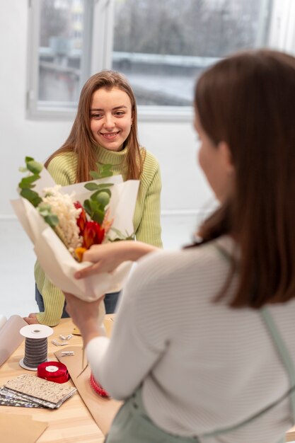 Mulheres criando um buquê de flores