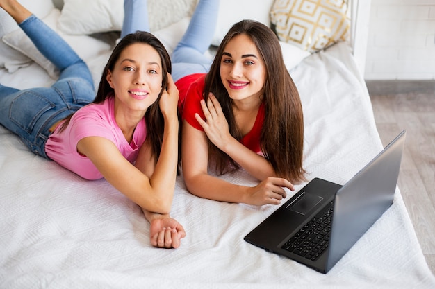 Mulheres de alto ângulo com laptop na cama