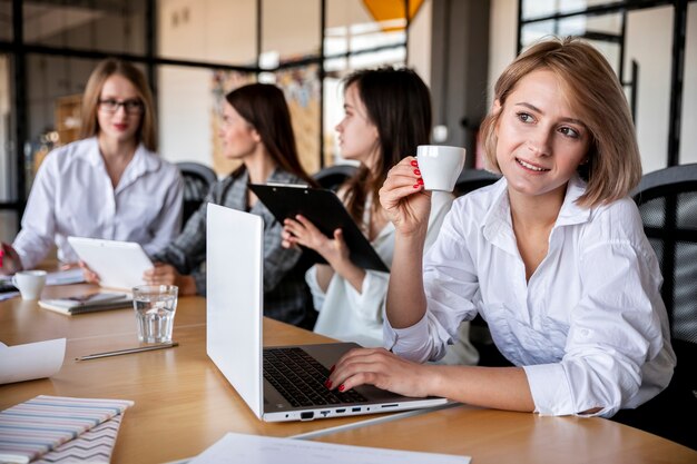 Mulheres de alto ângulo trabalhando e bebendo café