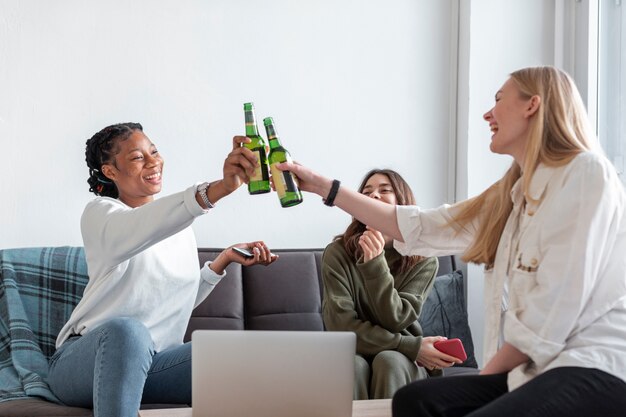 Mulheres de baixo ângulo em casa brindando