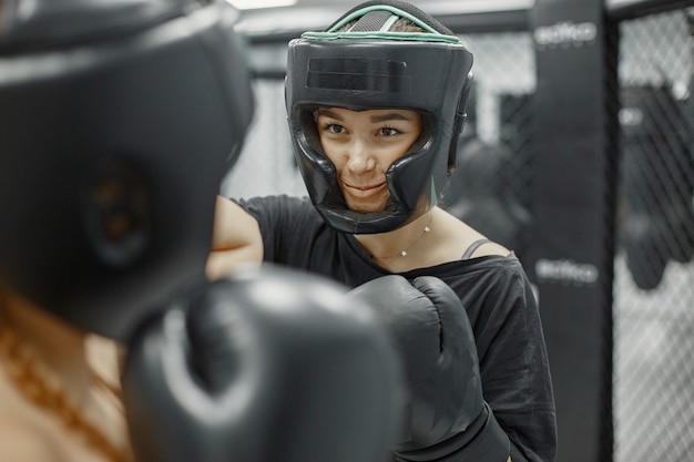 Mulheres de boxe. Iniciantes em uma academia. Senhora em uma roupa esporte preta.