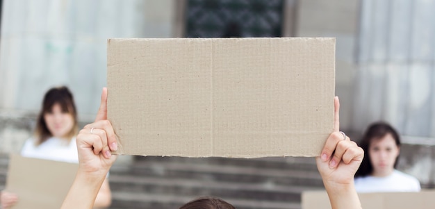 Mulheres de close-up segurando placas de papelão em protesto