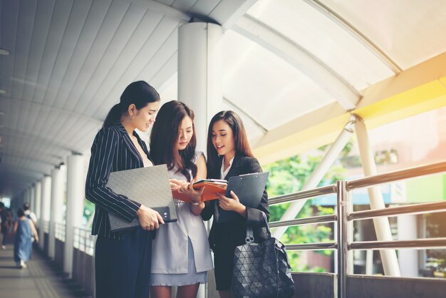 Mulheres de negócios discutindo sobre papelada em conjunto contra trilhos. Conceito de pessoas de negócios.