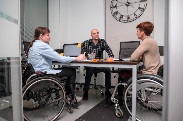Foto grátis mulheres de negócios em visão longa de cadeira de rodas