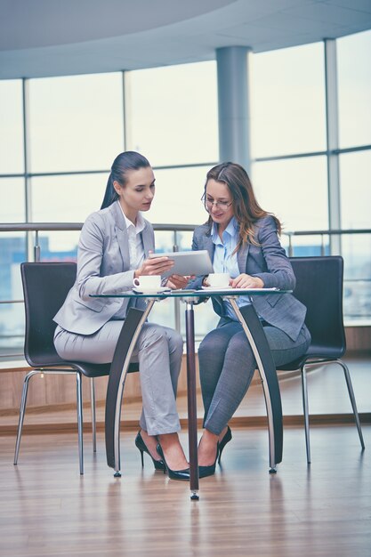 Mulheres de negócios inteligentes que trabalham com um tablet