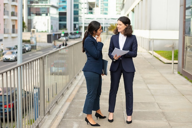 Mulheres de negócios profissionais que discutem papéis