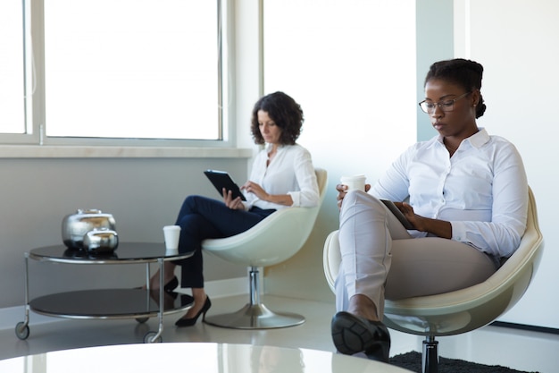 Mulheres de negócios que apreciam o trabalho quebram na sala de escritório