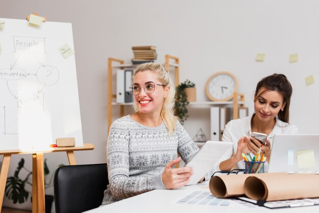Mulheres de negócios sorridente, sentado no escritório