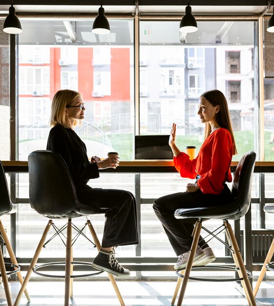 Mulheres de negócios usando linguagem de sinais no trabalho para falar umas com as outras