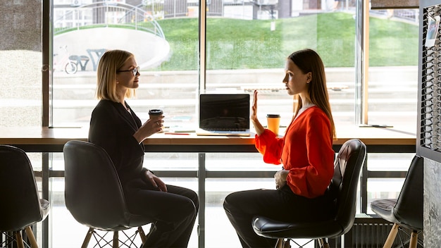 Mulheres de negócios usando linguagem de sinais no trabalho