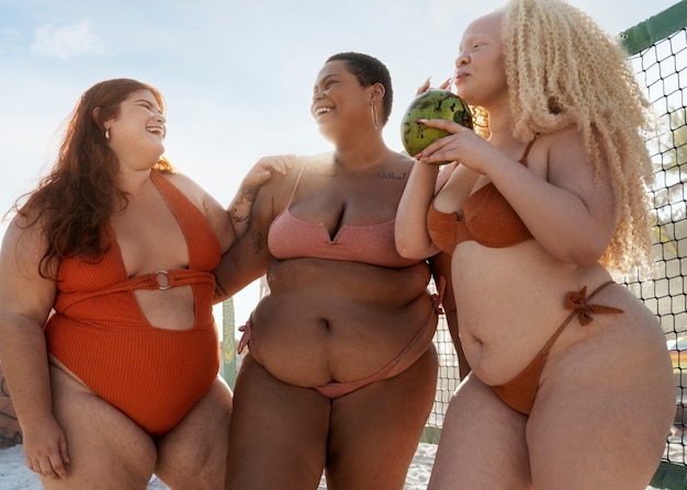 Mulheres de tamanho maior posando à beira-mar