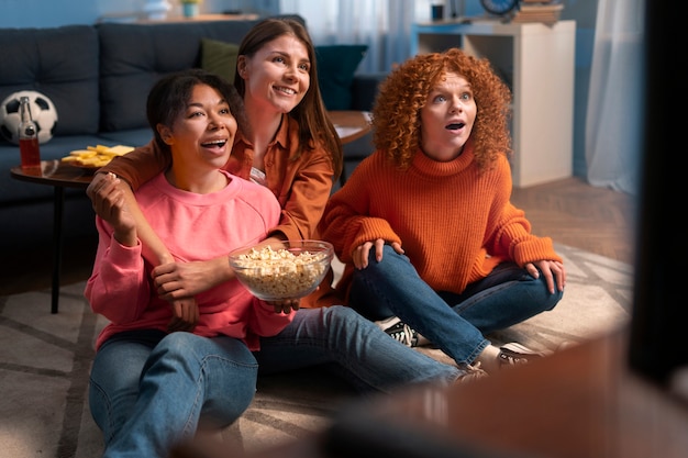 Mulheres de tiro completo assistindo esportes