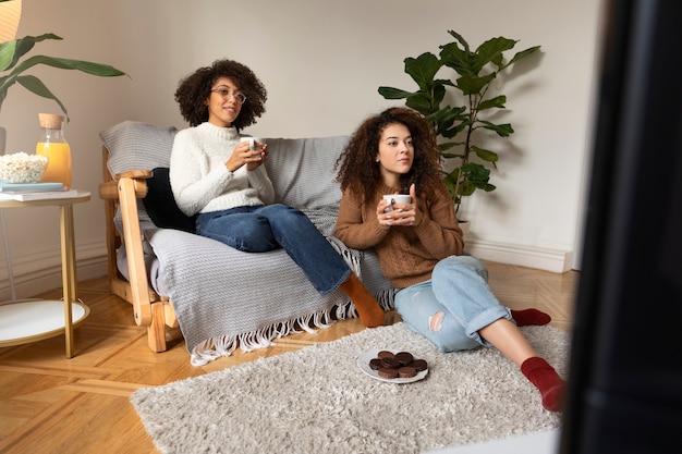 Foto grátis mulheres de tiro completo assistindo tv