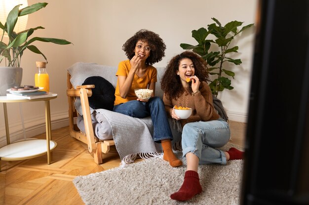 Mulheres de tiro completo comendo lanches