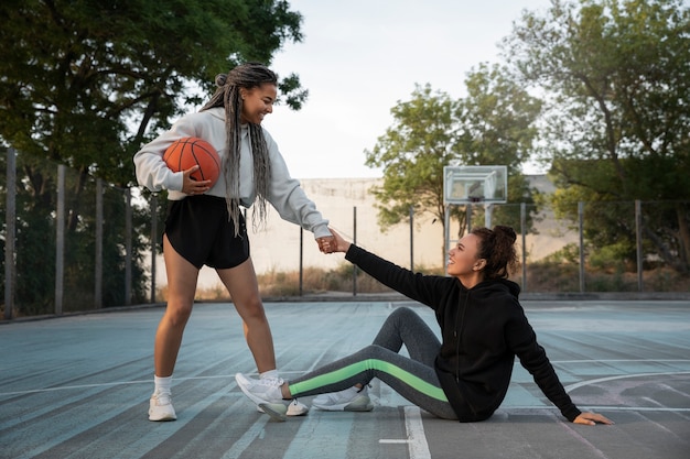 Mulheres de tiro completo jogando basquete