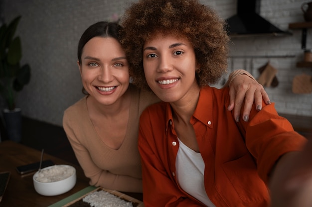 Mulheres de tiro médio aprendendo a fazer sushi