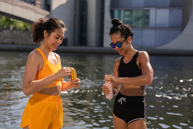 Mulheres de tiro médio com banana e água