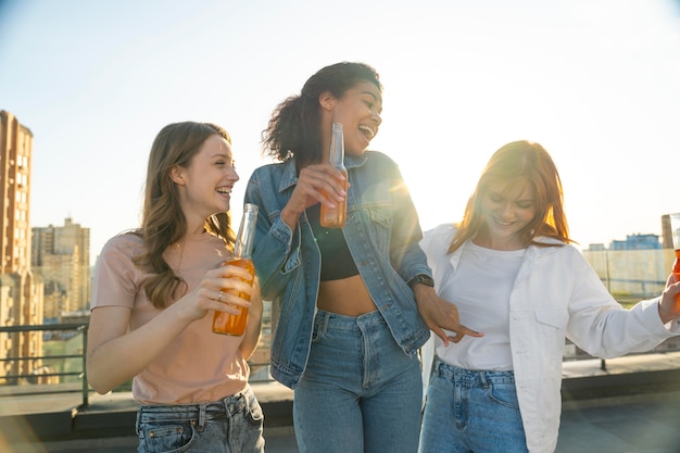 Mulheres de tiro médio com bebidas ao ar livre